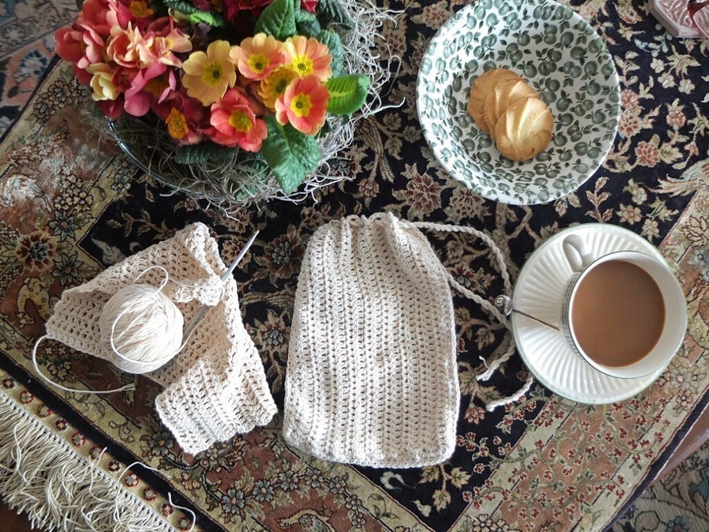 Visite haakwerkje met kopje koffie op Perzisch tapijtje