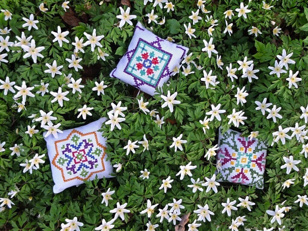 Geborduurde kussentjes tussen Bosannemonen
