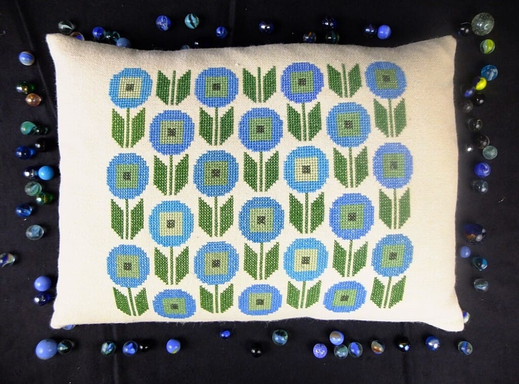 Kussen geborduurd met gestileerde bloemen