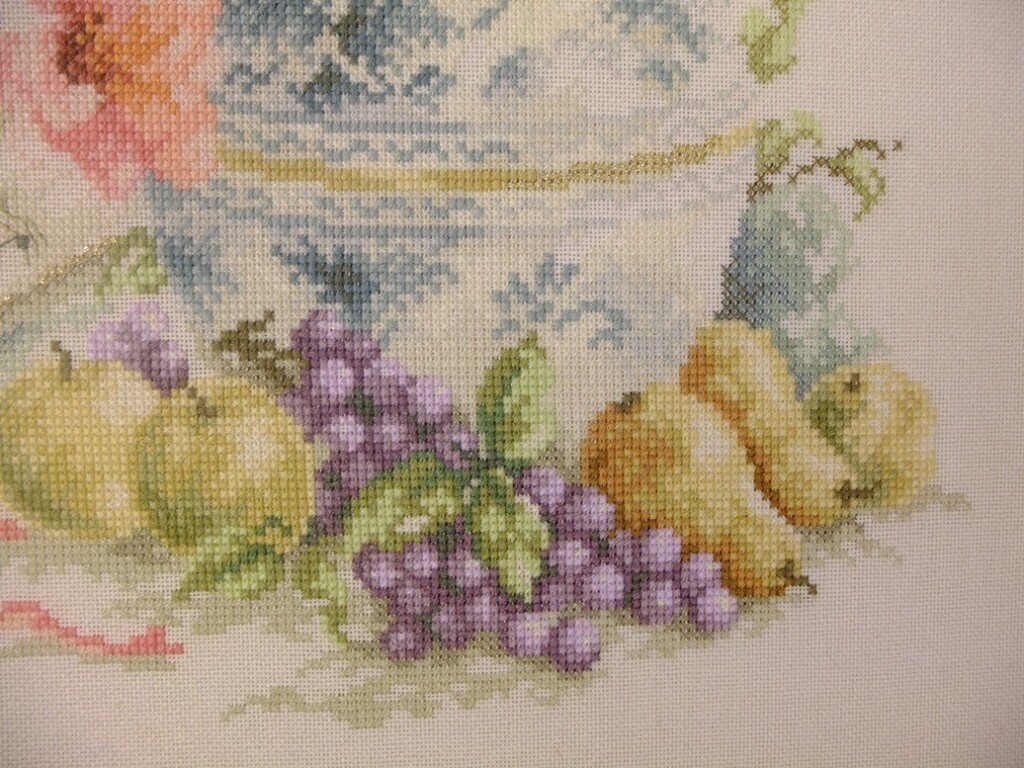 Detail geborduurd schilderij fruit bij vaas