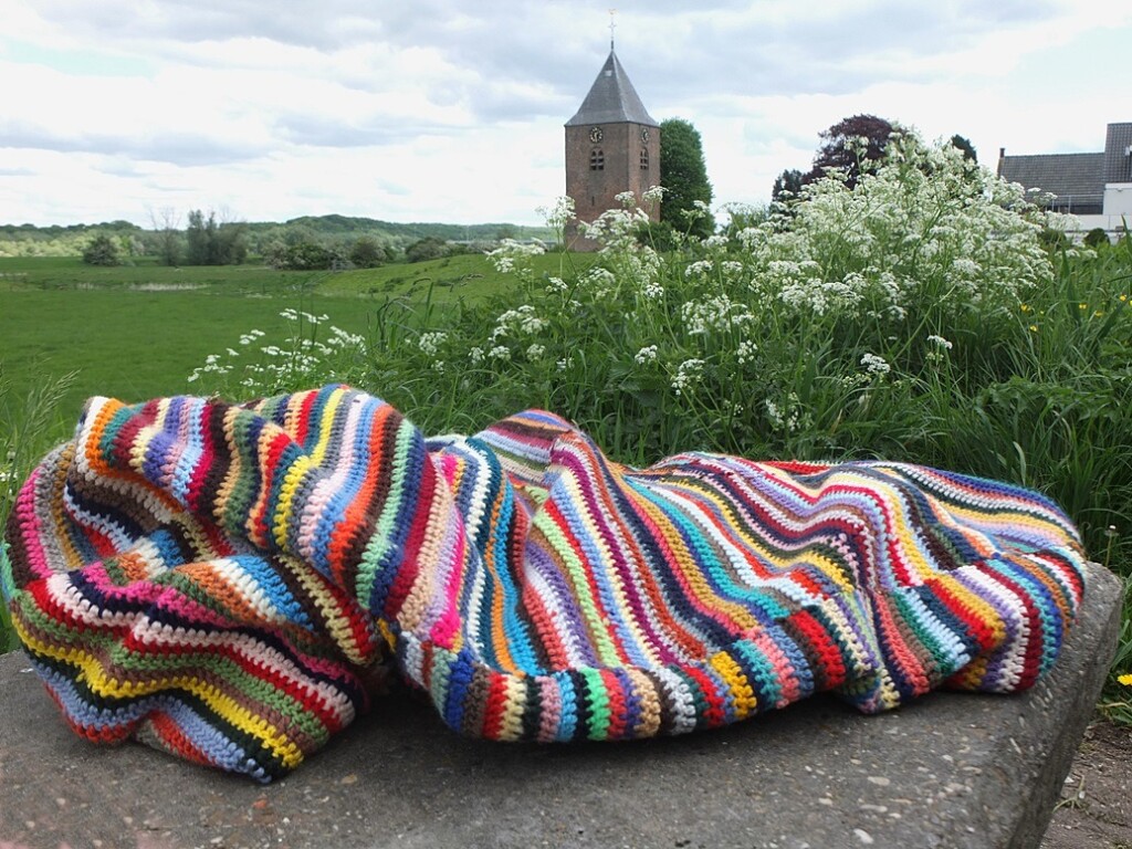 Gehaakte deken tegen achtergrond toren