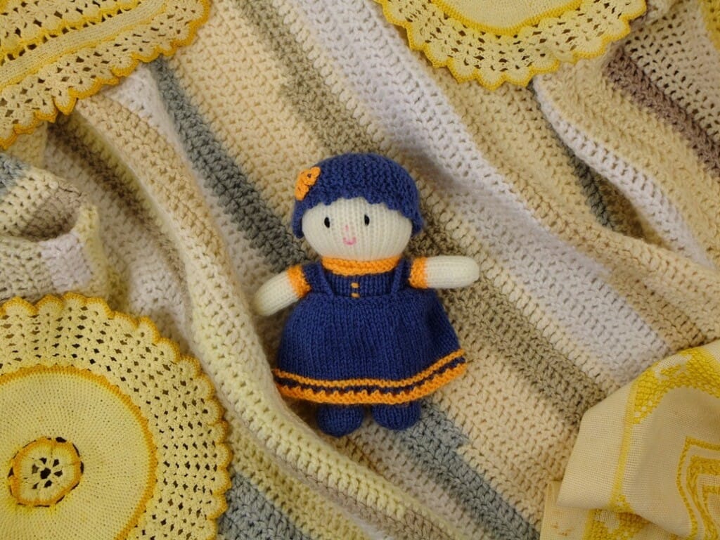 Gebreid poppetje tussen haakwerk