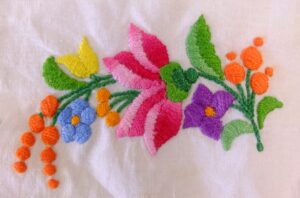Geborduurd bloemetje in platsteek