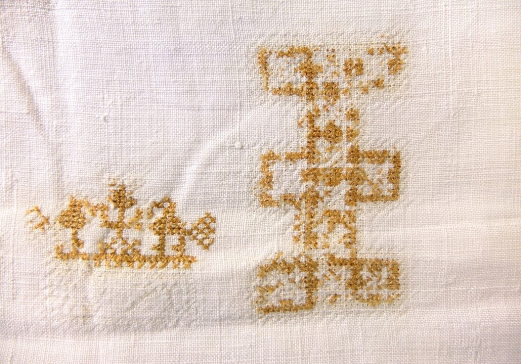 Half uitgehaalde letter op antiek linnen