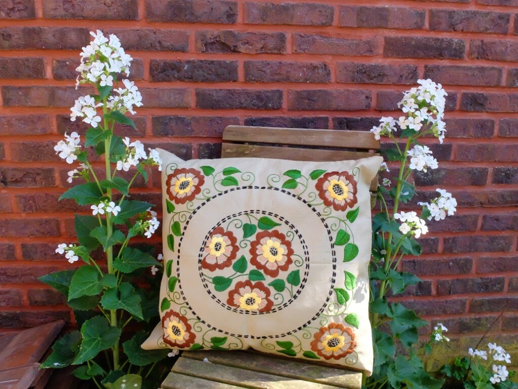 Geborduurd kussen bij witte judaspenning