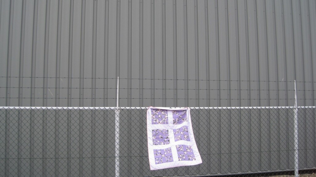 Sampler quilt aan hek